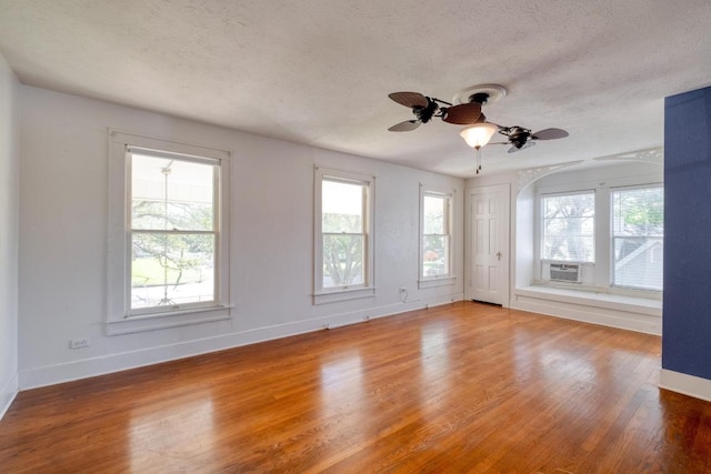 700 S Walnut Ave, Luling, TX 78648 - spare room with wood finished floors, a textured ceiling, cooling unit, and a ceiling fan