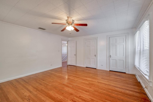 700 S Walnut Ave, Luling, TX 78648 - unfurnished bedroom with light wood finished floors, crown molding, and ceiling fan