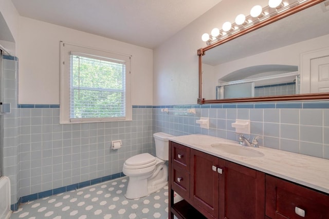 700 S Walnut Ave, Luling, TX 78648 - bathroom with a shower with door, tile walls, vanity, and wainscoting
