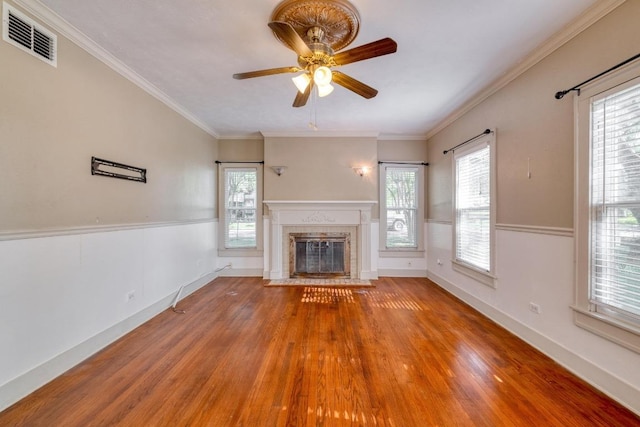 700 S Walnut Ave, Luling, TX 78648 - unfurnished living room with wood finished floors, a ceiling fan, a fireplace with flush hearth, plenty of natural light, and ornamental molding