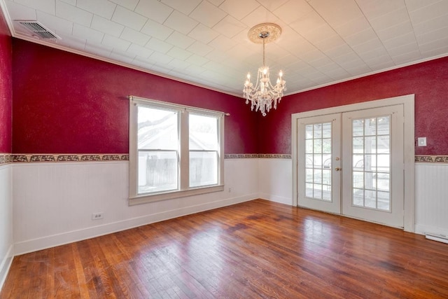 700 S Walnut Ave, Luling, TX 78648 - spare room with a chandelier, wood finished floors, french doors, a wainscoted wall, and crown molding