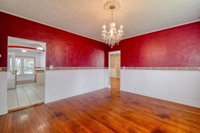 700 S Walnut Ave, Luling, TX 78648 - empty room featuring wood-type flooring, a chandelier, wainscoting, ceiling fan, and crown molding