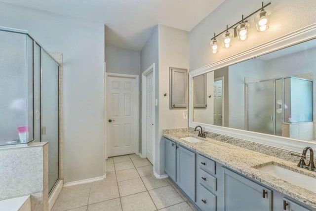 1515 Kothman Dr, Hutto, TX 78634 - full bath featuring a shower stall, double vanity, tile patterned flooring, and baseboards