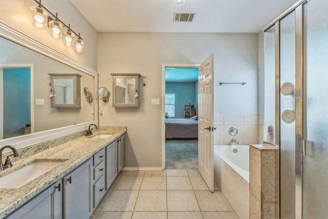 1515 Kothman Dr, Hutto, TX 78634 - ensuite bathroom featuring a bath, double vanity, tile patterned floors, a shower stall, and baseboards