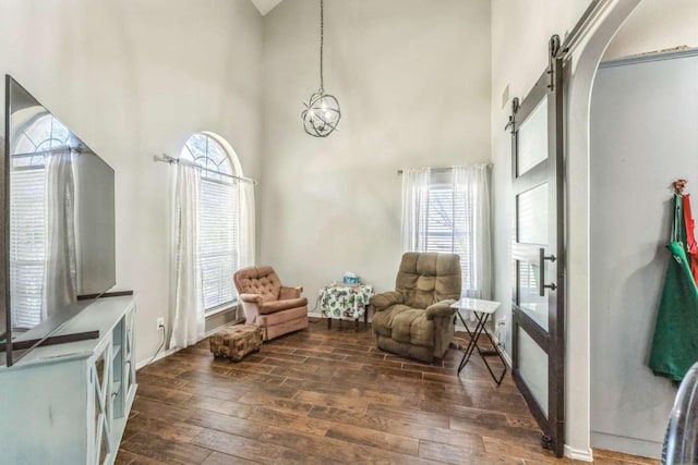 1515 Kothman Dr, Hutto, TX 78634 - living area with a barn door, wood-type flooring, plenty of natural light, and a high ceiling