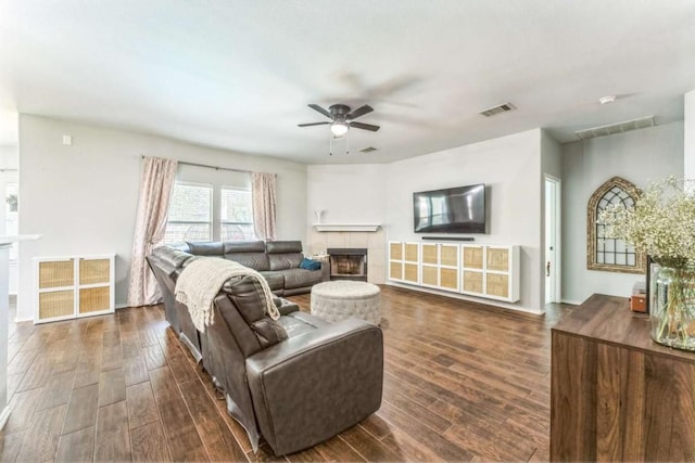 1515 Kothman Dr, Hutto, TX 78634 - living area featuring a tiled fireplace, ceiling fan, and dark wood-type flooring