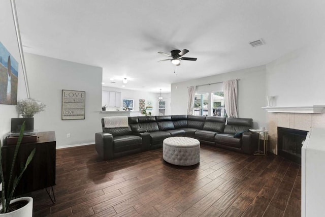1515 Kothman Dr, Hutto, TX 78634 - living room featuring dark wood-style flooring, ceiling fan, and a fireplace