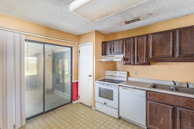 810 San Jacinto St, Lockhart, TX 78644 - kitchen featuring white appliances, under cabinet range hood, dark brown cabinetry, light countertops, and a textured ceiling