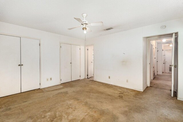 810 San Jacinto St, Lockhart, TX 78644 - unfurnished bedroom with multiple closets, carpet flooring, and ceiling fan