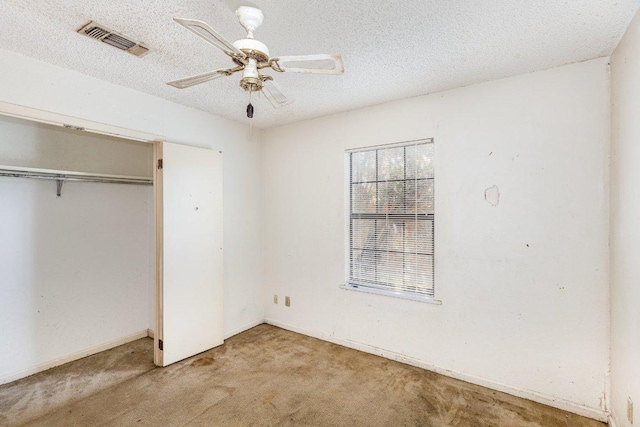 810 San Jacinto St, Lockhart, TX 78644 - unfurnished bedroom featuring carpet flooring, a closet, a ceiling fan, and a textured ceiling