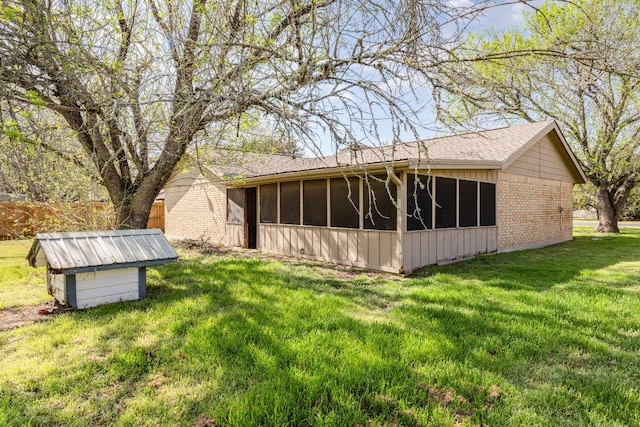 810 San Jacinto St, Lockhart, TX 78644 - back of house featuring a sunroom, brick siding, and a lawn