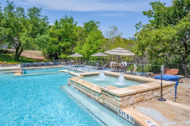 6000 Shepherd Mountain Cv Unit 407, Austin, TX 78730 - view of swimming pool featuring a patio area, a pool with connected hot tub, and view of wooded area