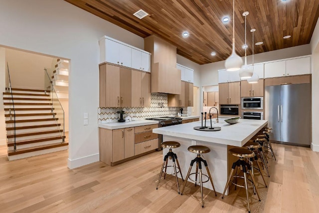 4800 Mondonedo Cv, Austin, TX 78738 - kitchen with stainless steel appliances, a breakfast bar area, wooden ceiling, light wood-style floors, and light countertops