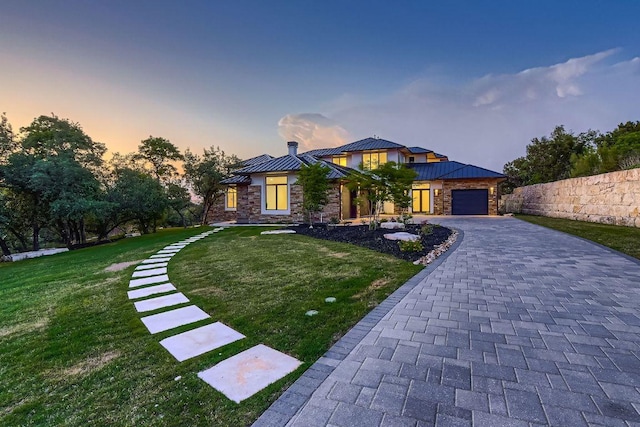 4800 Mondonedo Cv, Austin, TX 78738 - view of front of home with a standing seam roof, metal roof, a front lawn, stone siding, and an attached garage