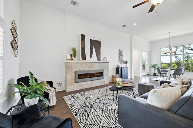 5200 Patagonia Pass, Austin, TX 78738 - living room featuring wood finished floors, a ceiling fan, a tile fireplace, a chandelier, and ornamental molding