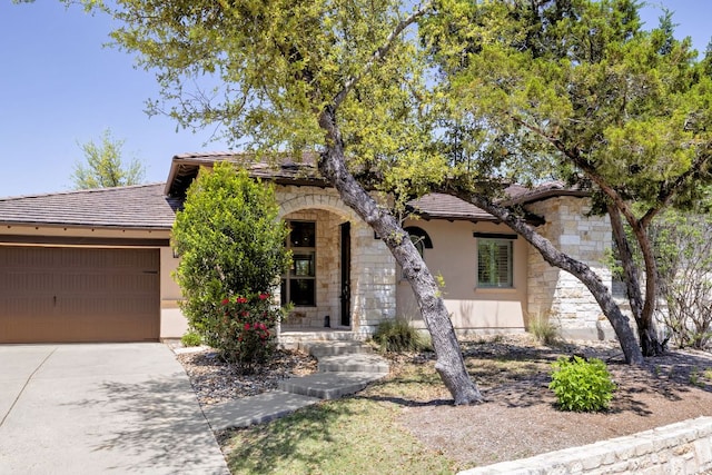 5200 Patagonia Pass, Austin, TX 78738 - view of front of home featuring stone siding, a garage, driveway, and stucco siding