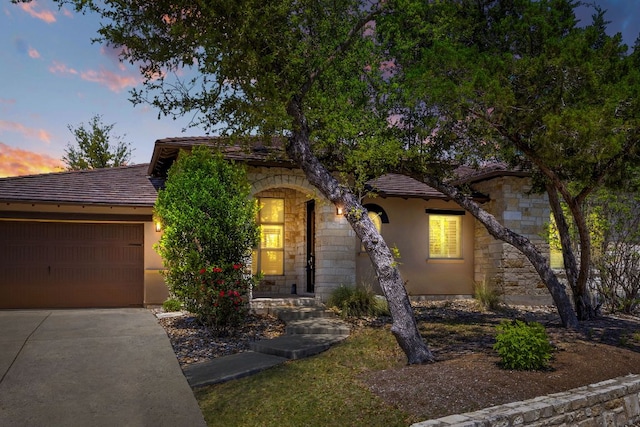 5200 Patagonia Pass, Austin, TX 78738 - view of front of home featuring stone siding, concrete driveway, an attached garage, and stucco siding