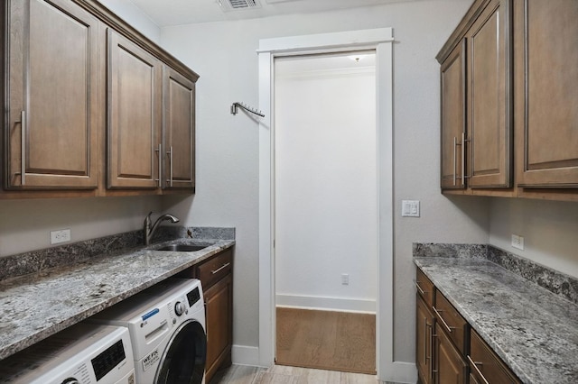 5200 Patagonia Pass, Austin, TX 78738 - laundry room with separate washer and dryer, cabinet space, and light wood-style flooring