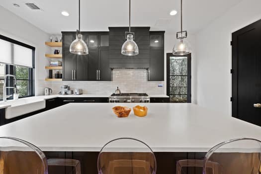 802 Pressler St, Austin, TX 78703 - kitchen featuring light countertops, a kitchen island, open shelves, tasteful backsplash, and dark cabinets