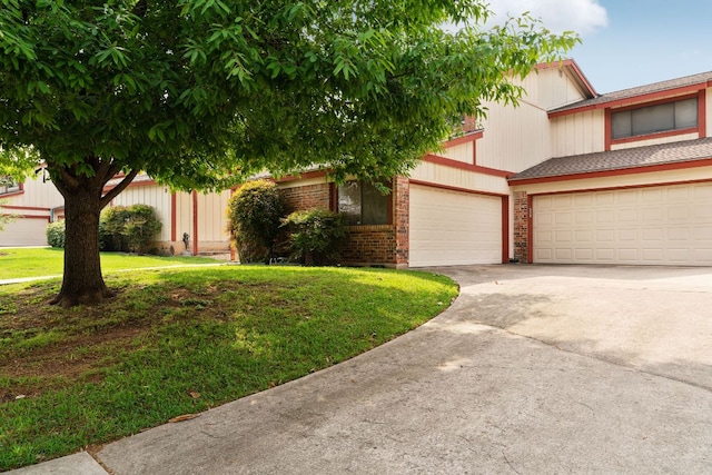 8902 Trone Cir Unit A, Austin, TX 78758 - view of front facade featuring driveway, an attached garage, brick siding, and a front lawn