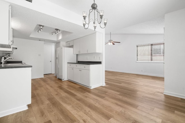 8902 Trone Cir Unit A, Austin, TX 78758 - kitchen with freestanding refrigerator, dark countertops, a tray ceiling, ceiling fan, and light wood-type flooring