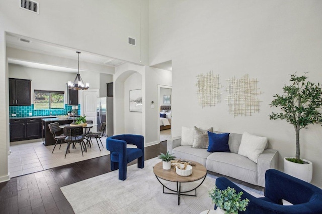 2001 Faro Dr Unit 29, Austin, TX 78741 - living room featuring a towering ceiling, a notable chandelier, wood finished floors, and visible vents