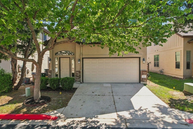 2001 Faro Dr Unit 29, Austin, TX 78741 - view of front of home featuring central AC, stucco siding, brick siding, an attached garage, and driveway