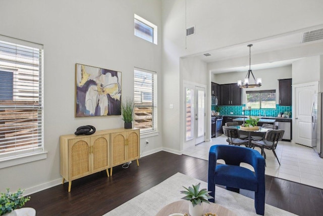 2001 Faro Dr Unit 29, Austin, TX 78741 - living area featuring a chandelier, a high ceiling, visible vents, and light wood-type flooring