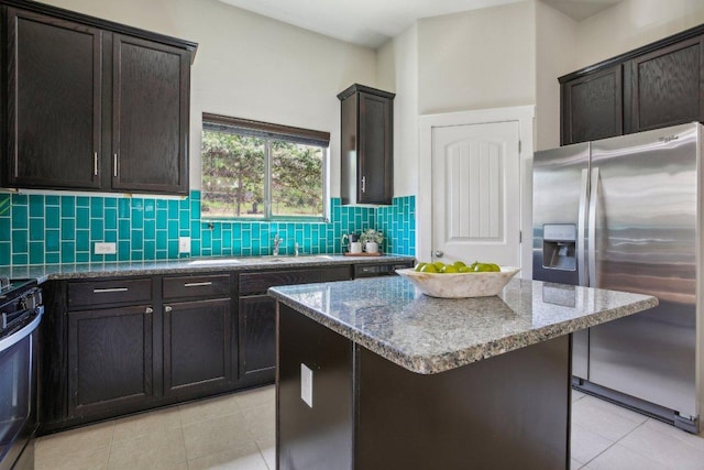 2001 Faro Dr Unit 29, Austin, TX 78741 - kitchen featuring light tile patterned floors, appliances with stainless steel finishes, stone countertops, and backsplash