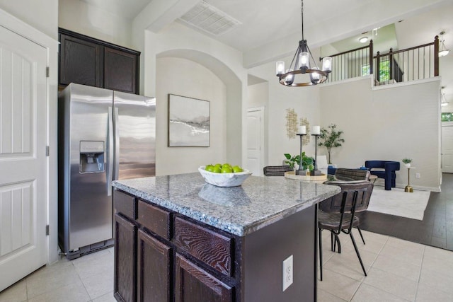 2001 Faro Dr Unit 29, Austin, TX 78741 - kitchen featuring visible vents, an inviting chandelier, a kitchen island, stainless steel refrigerator with ice dispenser, and light stone counters