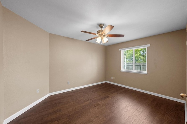 empty room featuring ceiling fan, baseboards, and dark wood-type flooring