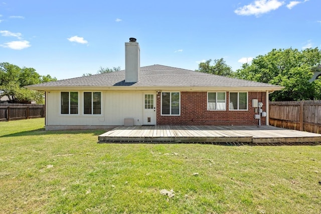 back of property featuring a wooden deck, a fenced backyard, a chimney, brick siding, and a lawn