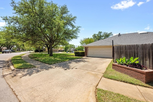 view of home's exterior with fence, a lawn, driveway, and a garage