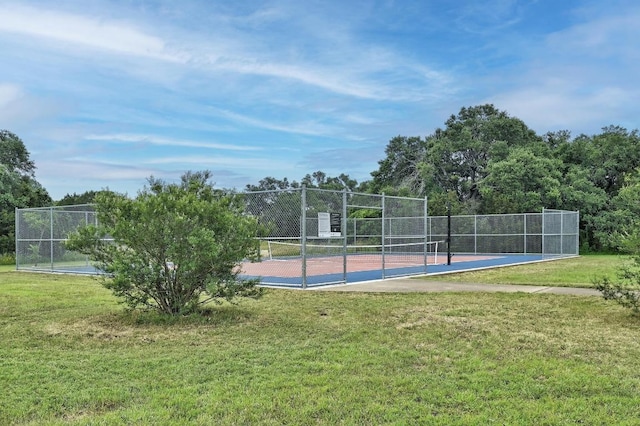 view of basketball court featuring fence, a yard, and a tennis court