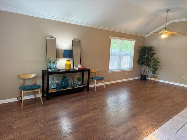 living area featuring ornamental molding, wood finished floors, baseboards, a ceiling fan, and vaulted ceiling