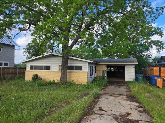 single story home featuring brick siding, driveway, and fence