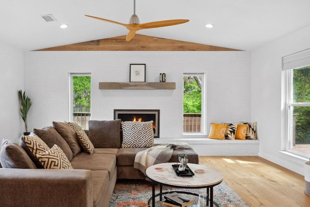 1803 Cedar Ridge Dr, Austin, TX 78741 - living room featuring lofted ceiling, wood finished floors, a ceiling fan, baseboards, and a lit fireplace