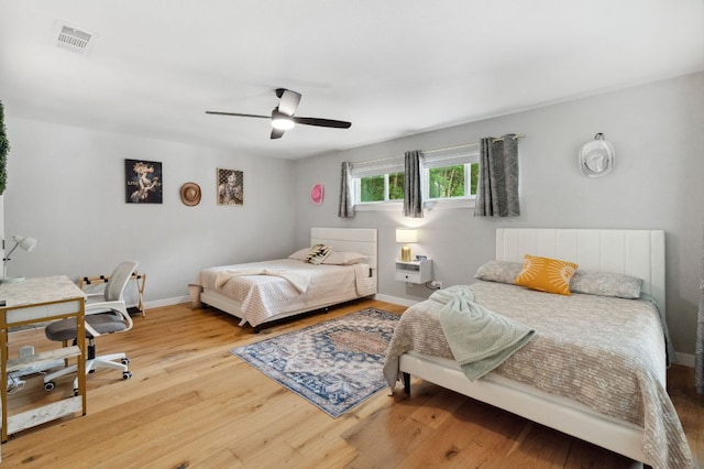 1803 Cedar Ridge Dr, Austin, TX 78741 - bedroom with wood finished floors, ceiling fan, a desk, and baseboards
