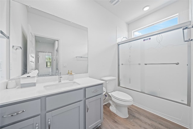 18005 Umberto Dr, Pflugerville, TX 78660 - bathroom featuring wood finished floors, vanity, and shower / bath combination with glass door
