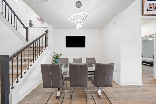 18005 Umberto Dr, Pflugerville, TX 78660 - dining area featuring stairs, wood finished floors, and a chandelier