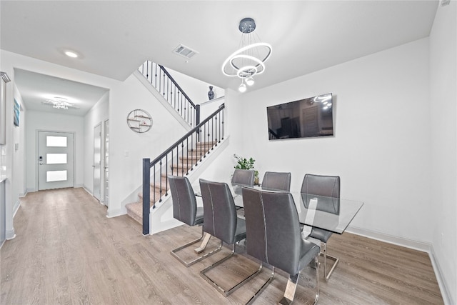 18005 Umberto Dr, Pflugerville, TX 78660 - dining space featuring light wood-style floors, stairs, and baseboards