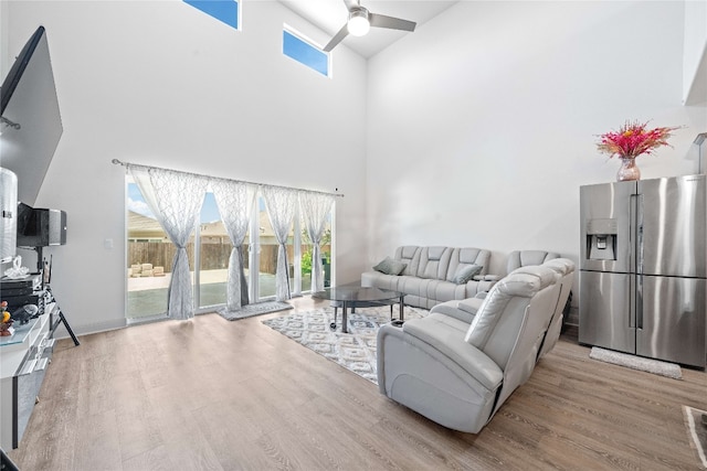 18005 Umberto Dr, Pflugerville, TX 78660 - living room with a high ceiling, a ceiling fan, and wood finished floors
