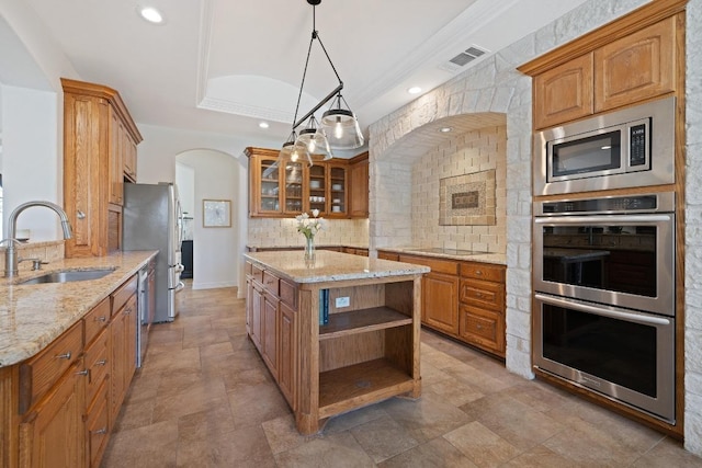1310 Ventana Cyn, Leander, TX 78641 - kitchen with stainless steel appliances, open shelves, tasteful backsplash, arched walkways, and light stone counters