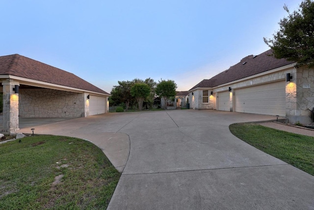 1310 Ventana Cyn, Leander, TX 78641 - view of side of property featuring stone siding, concrete driveway, a lawn, a garage, and roof with shingles