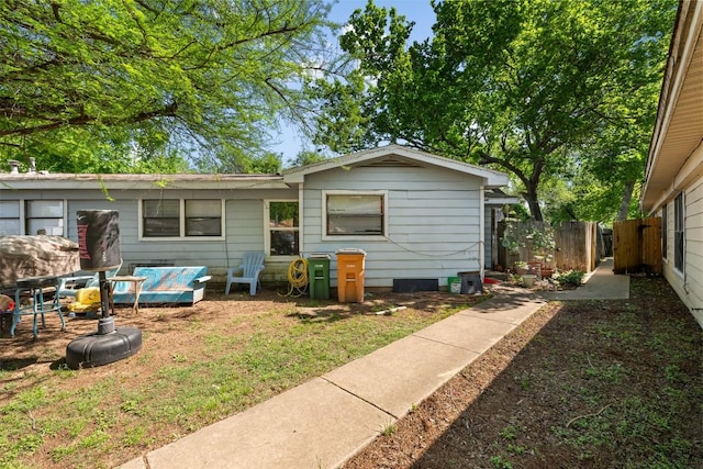 rear view of property featuring fence