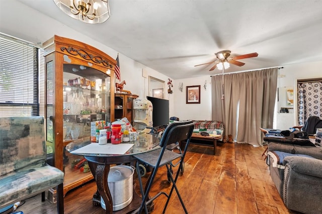 dining space with wood-type flooring and ceiling fan with notable chandelier