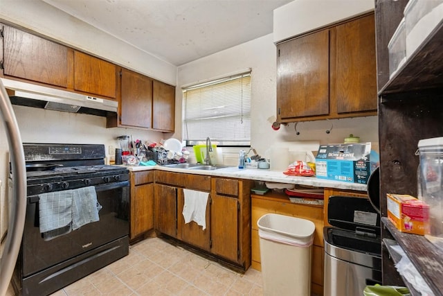 825 Ken St, Austin, TX 78758 - kitchen with a sink, light countertops, brown cabinetry, black range with gas cooktop, and under cabinet range hood