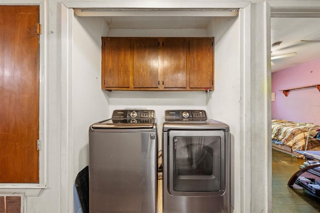 laundry room with separate washer and dryer, visible vents, and cabinet space