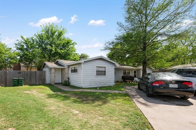 ranch-style house featuring fence and a front lawn