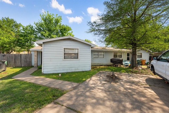 exterior space with a patio area, a front lawn, and fence